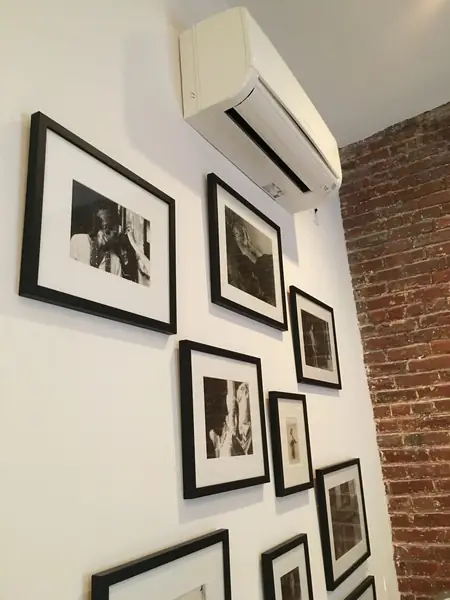 Ductless mini-split head above a gallery wall of frames