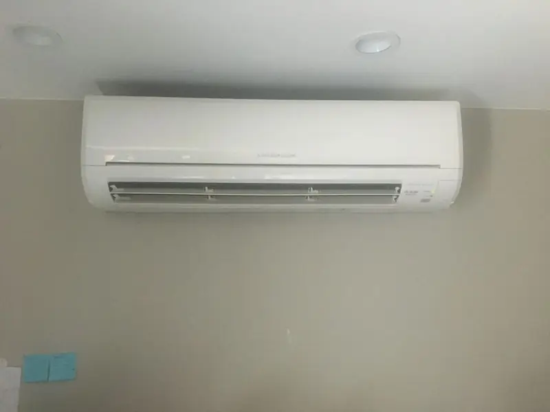 White ductless mini-split indoor head mounted high on a plain wall